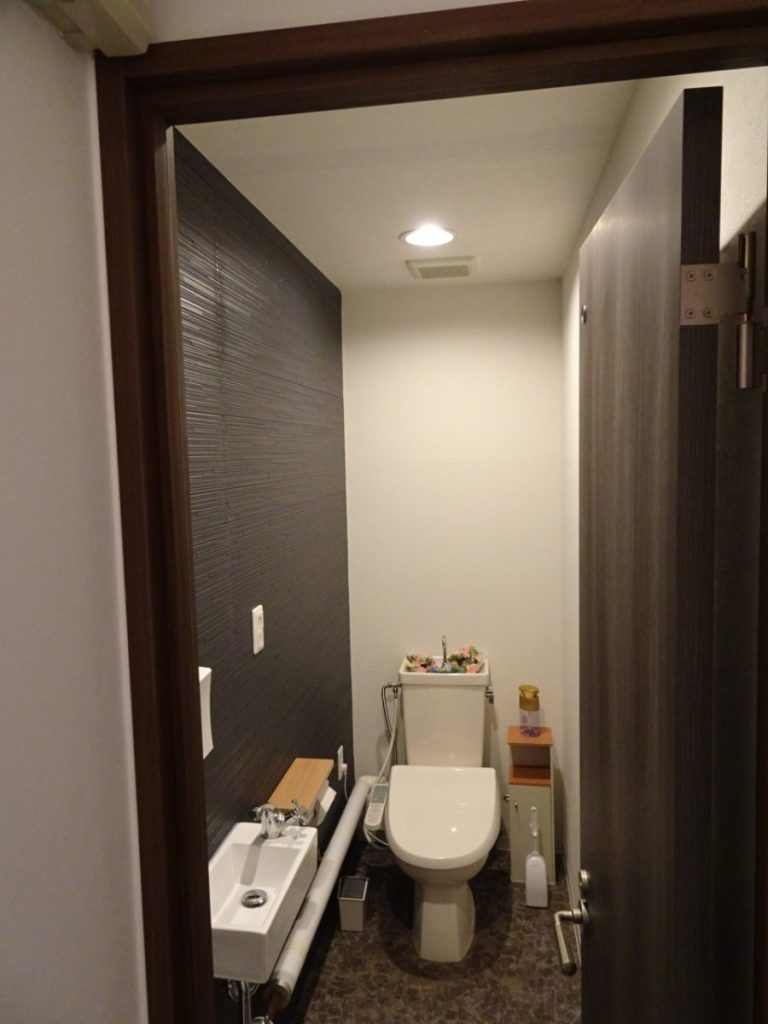 リフォーム工事後の美容室のトイレ扉（扉の位置が改善）